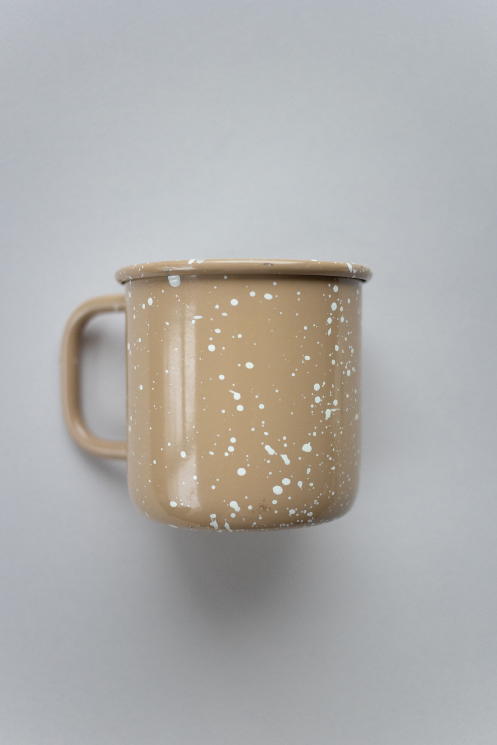 Speckled ceramic mug against a neutral background